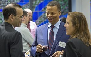 People stand and talk at a party.