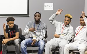 Several students raise their hands during a discussion.