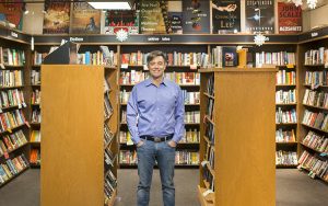Liam Callanan stands between two racks of books at Boswell Book Company.