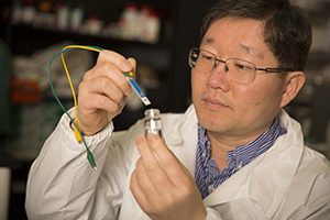 Woo-Jin Chang is puts a water sensor into a sample of water.