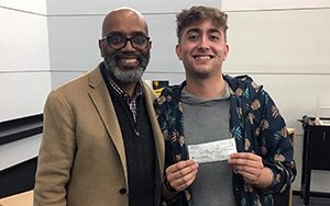 Jared Smith holds up a check.