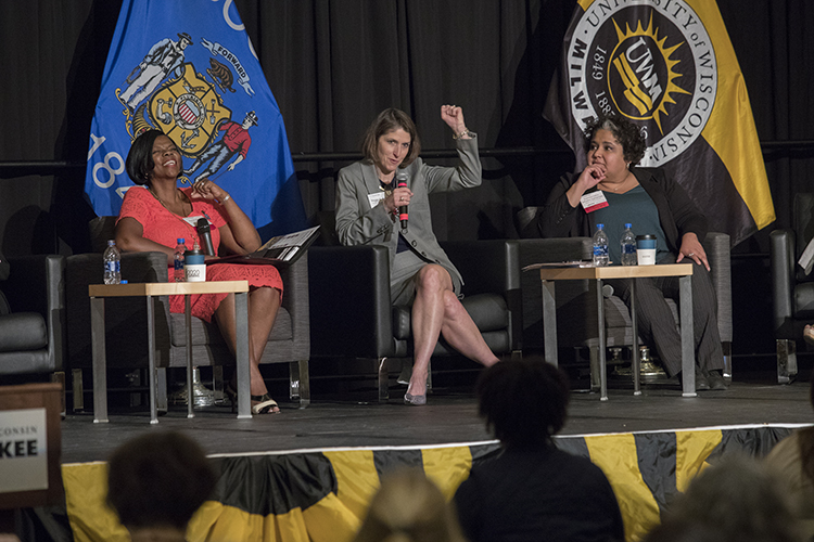 Three women sit on stage during a panel discussion.