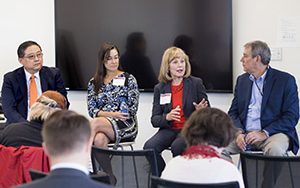 Four people sit and talk during a panel discussion.