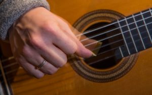 A hand strumming a guitar