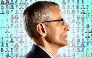 Image of professor in front of a mosaic of faces