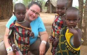 A woman poses with three small children in Tanzania.