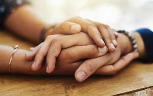 Image of two clasped hands, giving comfort