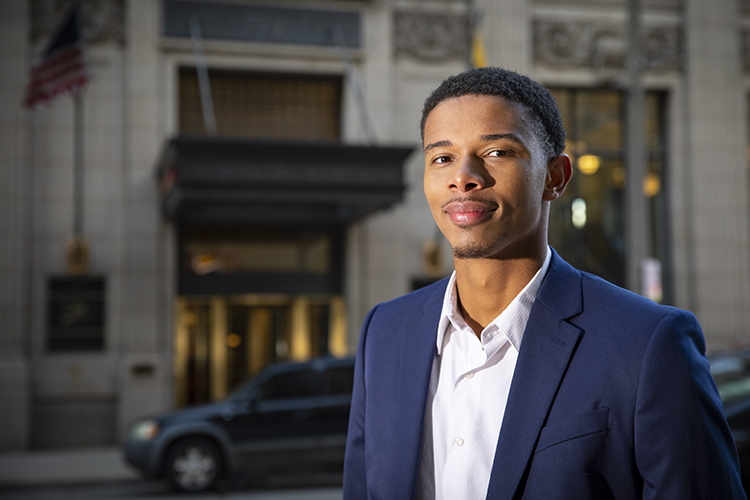 A man stands outside in front of a building.