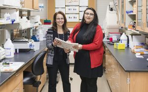 Two women stand in a lab.