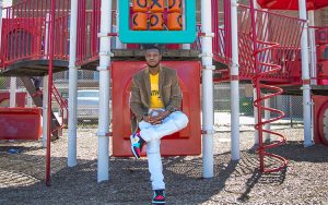 A man sits on some playground equipment.