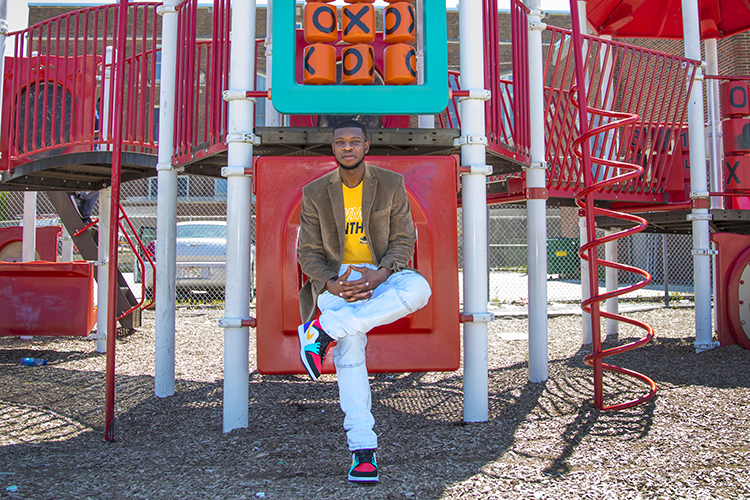A man sits on some playground equipment.