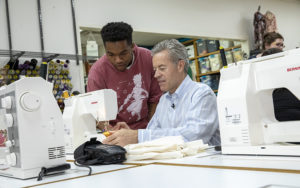 Mark Mone at sewing machine with student