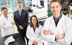 Researchers pose for picture in lab