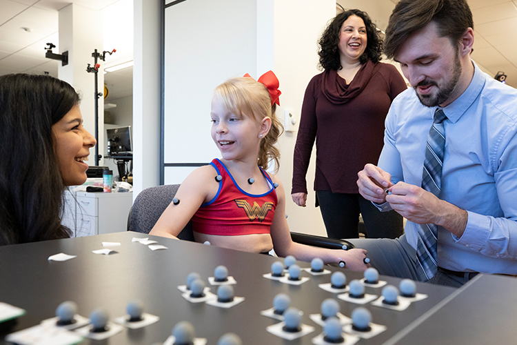 Researchers talk with young girl before test at mobility lab