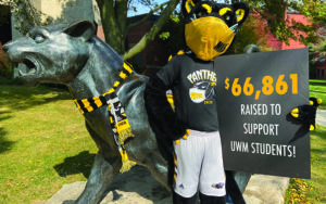 Photo shows Pounce holding the total raised by the 2020 Panther Prowl.