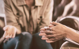 Image shows the hands of women in conversation.