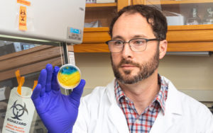 A researcher holds up a lab sample.