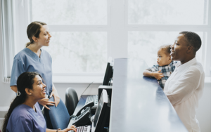 A patient talks with two medical staffers at a doctor's office.