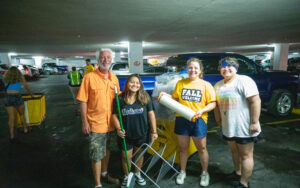 UWL student helpers Lillian Hayward, Carp Carpio helping incoming student Madalyn Ditlerson and her father move in