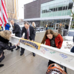 Chancellor Mone, Jim Harvey, and Kristen Murphy signing there names to the ceremonial last beam for chemistry building