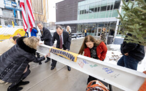 Chancellor Mone, Jim Harvey, and Kristen Murphy signing there names to the ceremonial last beam for chemistry building