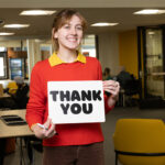 Student holding thank you sign