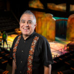 Alvaro Saar Rios smiling and standing in front of a stage.