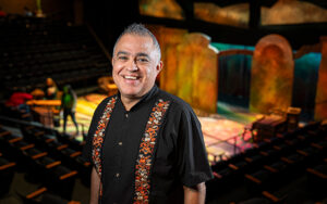 Alvaro Saar Rios smiling and standing in front of a stage.