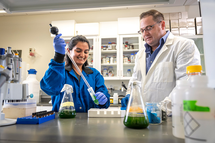 UWM professor Todd Miller and postdoctoral student Anjana Adhikari work together in the laboratory.