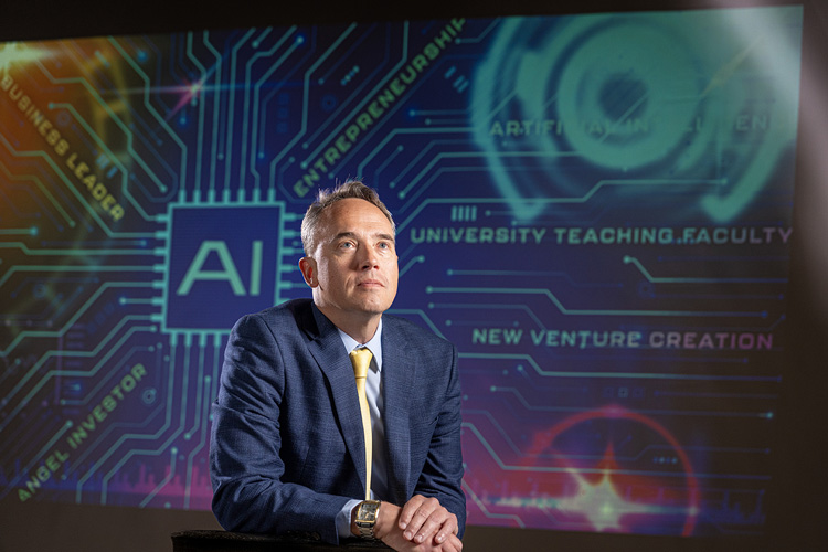 Matthew Friedel, co-founder of UWM’s Disruptive Technologies Lab, poses in front of a digital backdrop in the Cunningham Hall studio.