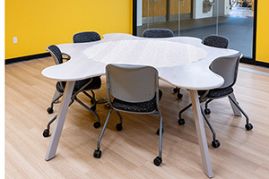 Photo shows a table that wraps halfway around six people