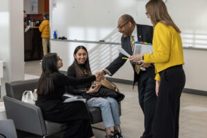 Chancellor Gibson greeting UWM students,Kayley Garcia, and Suheidy Nevarez before the roar ready event