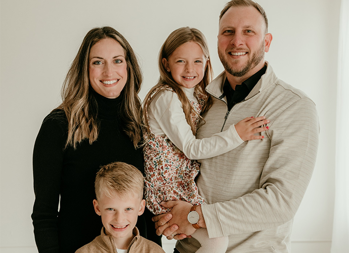 A man and woman stand with two children. 