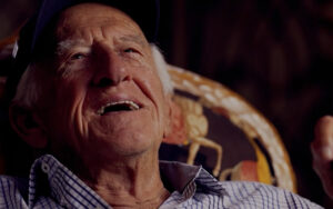 The late Milwaukee Brewers broadcaster Bob Uecker leans back while smiling.