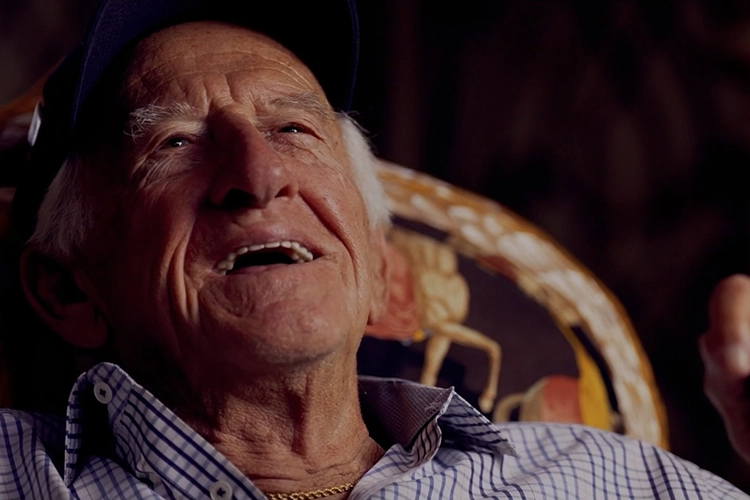 The late Milwaukee Brewers broadcaster Bob Uecker leans back while smiling.