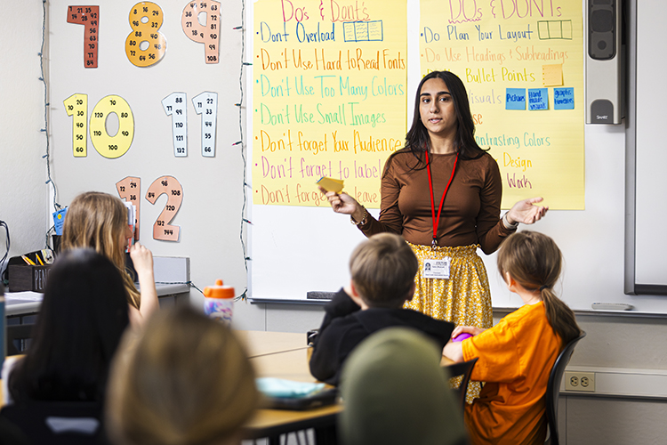 Sara Dharani stands at the front of a classroom of children