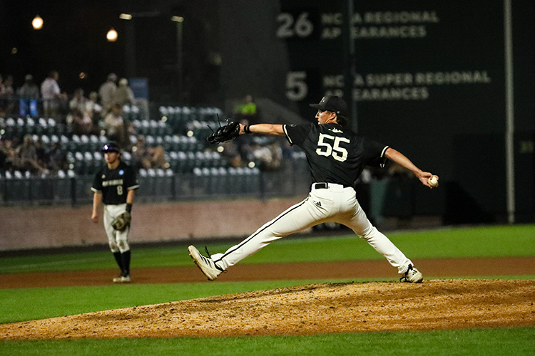 A man takes a long stride toward home plate while pitching.