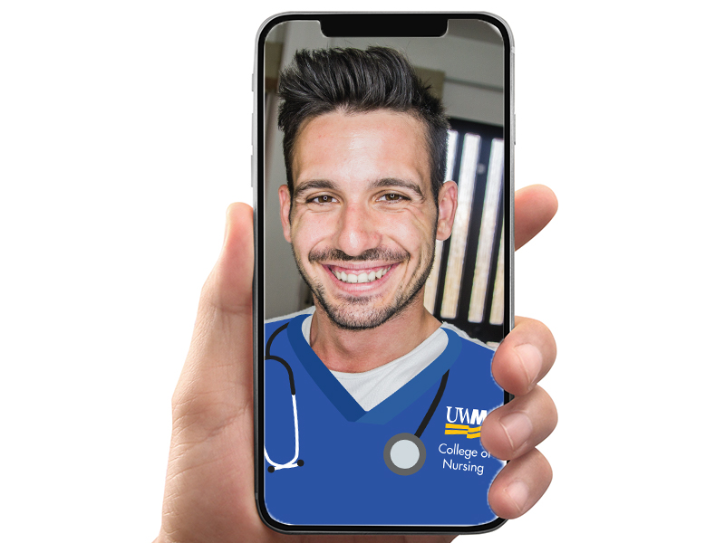 Man modeling the snapchat frame of nursing scrubs on a phone being held by someone's hand