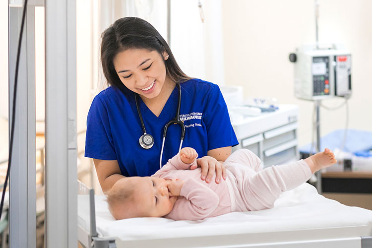 Nursing student Kim, with a baby in clinical room