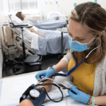 Melissa Mueller working on blood pressure on manikin arm