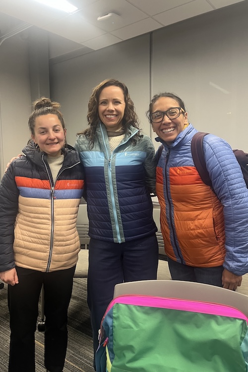 two nursing students and dr jeana holt smile together wearing puffy colorful coats