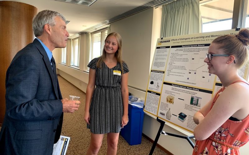 Two students present their research to the Dean of Letters and Science