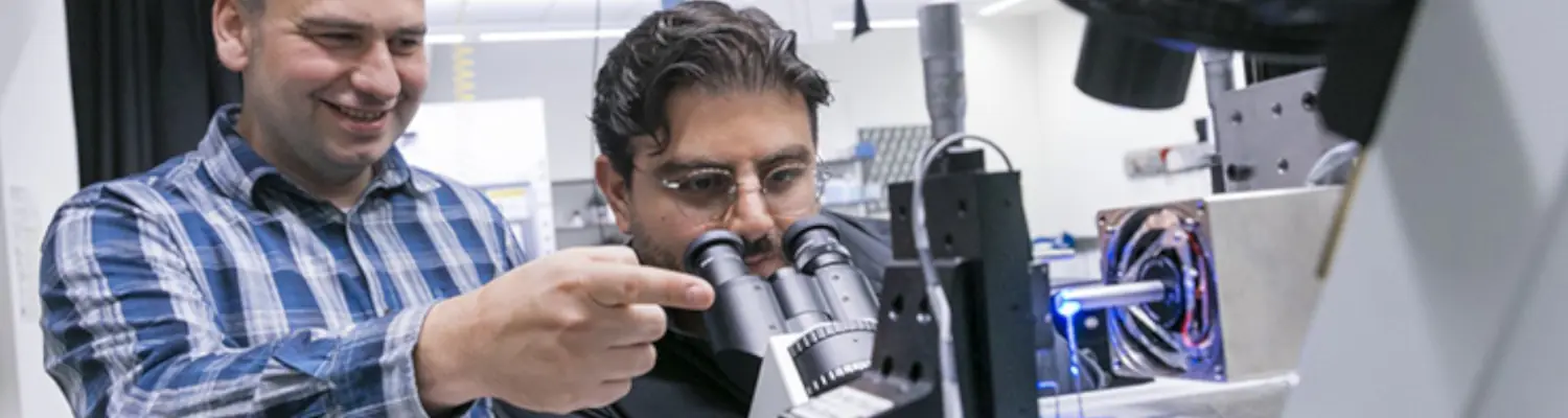 people looking through microscope in a lab