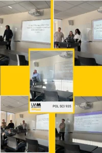 A young man and two friends stand on either side of a projector screen showing an image of the man's research project.