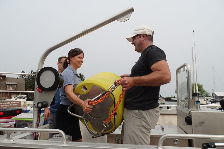 Brenda LaFrancois looks at the sensor system UW-Milwaukee researcher Todd Miller is about to deploy in the lake.