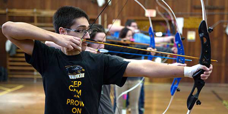 Students participating in an archery class
