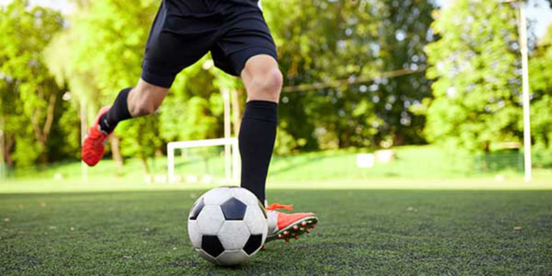 Close up of a soccer player kicking a ball
