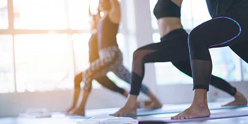 4 women exercising in fitness studio yoga classes