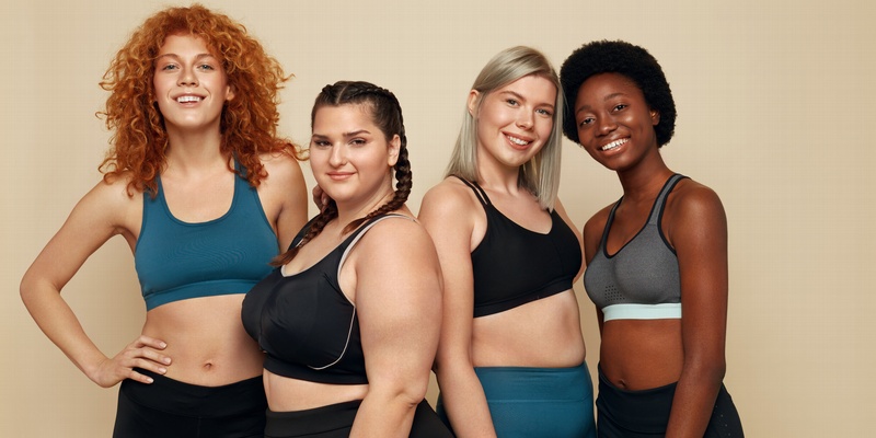 Four body positive women standing together.