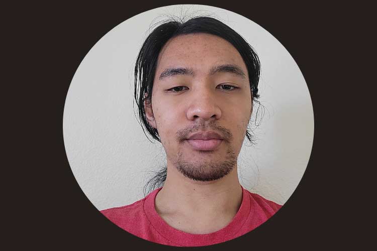 Asian man wearing red shirt with hair pulled back